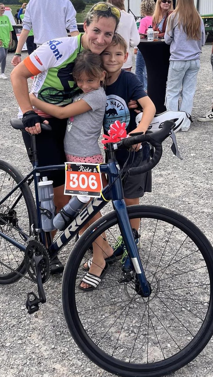 Team member Dr. Helen Caetano in cycling gear with family.