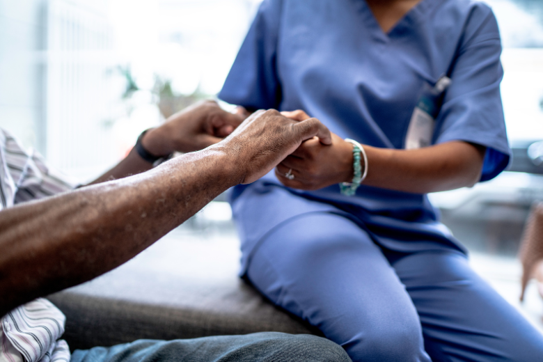 Healthcare practitioner holding patient's hands