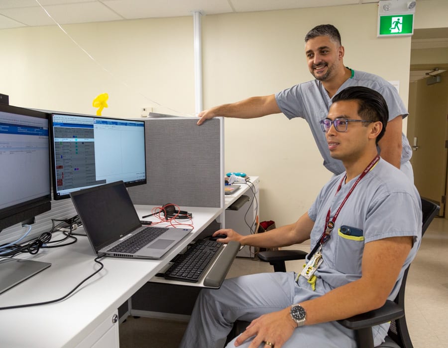 Dr. Ben Tam and Dr. Anthony Habib at a computer.