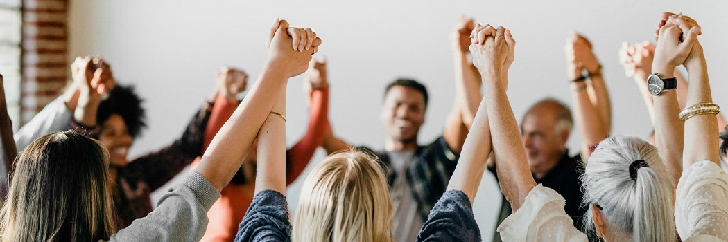 People holding hands in a circle supporting one another